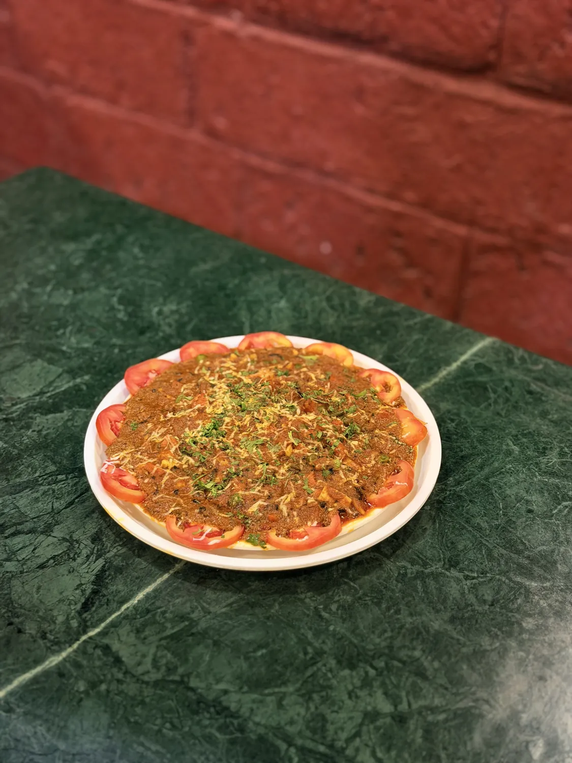 Mutton fry masala plate garnished with tomato