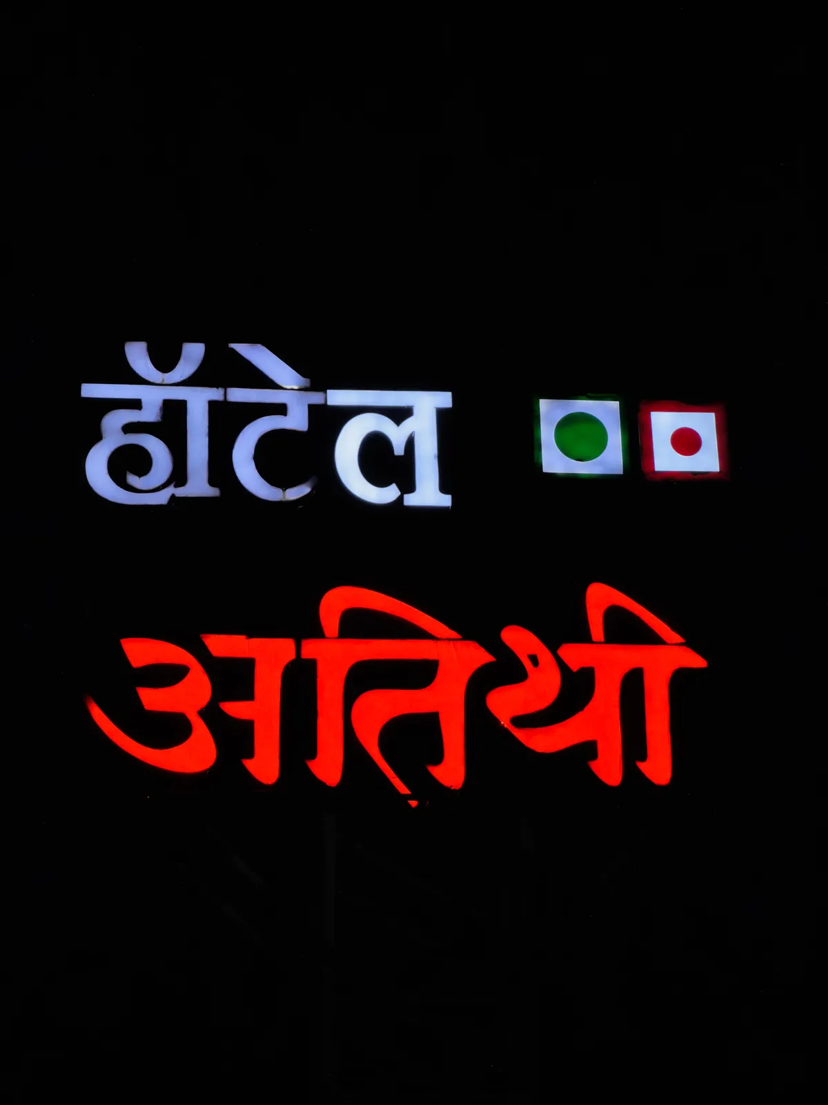 Close-up of the lit Hotel Atithi sign with veg and non-veg marks