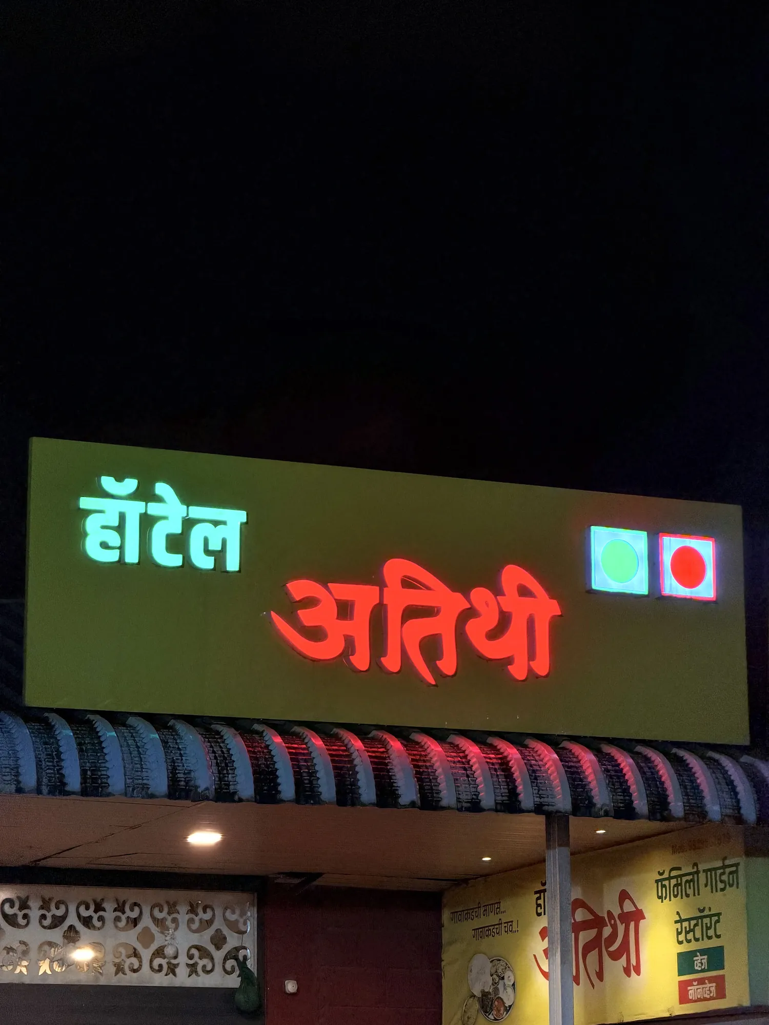 The illuminated Hotel Atithi signboard at night