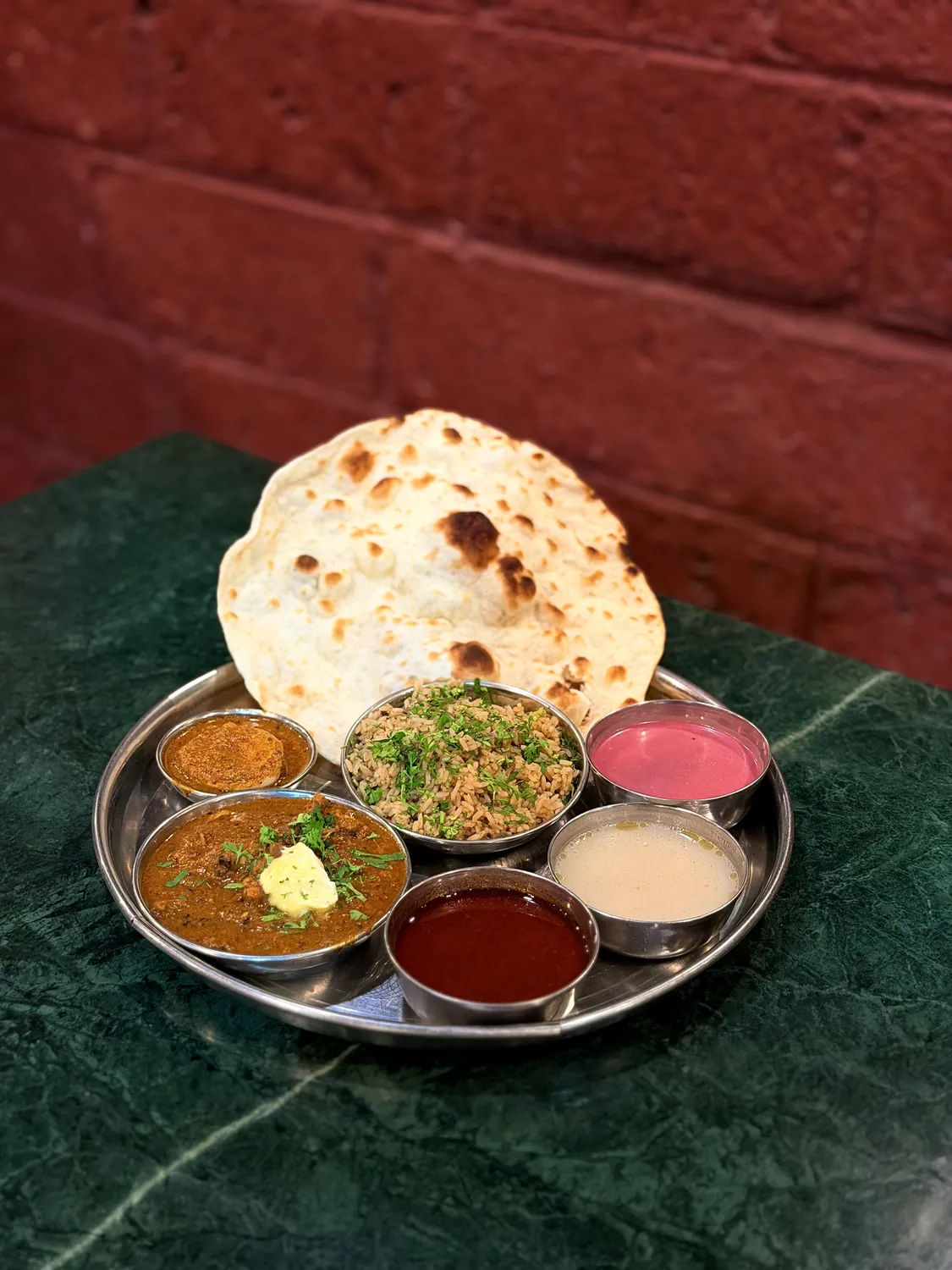 Mutton thali with butter-topped curry, bhakri and solkadhi