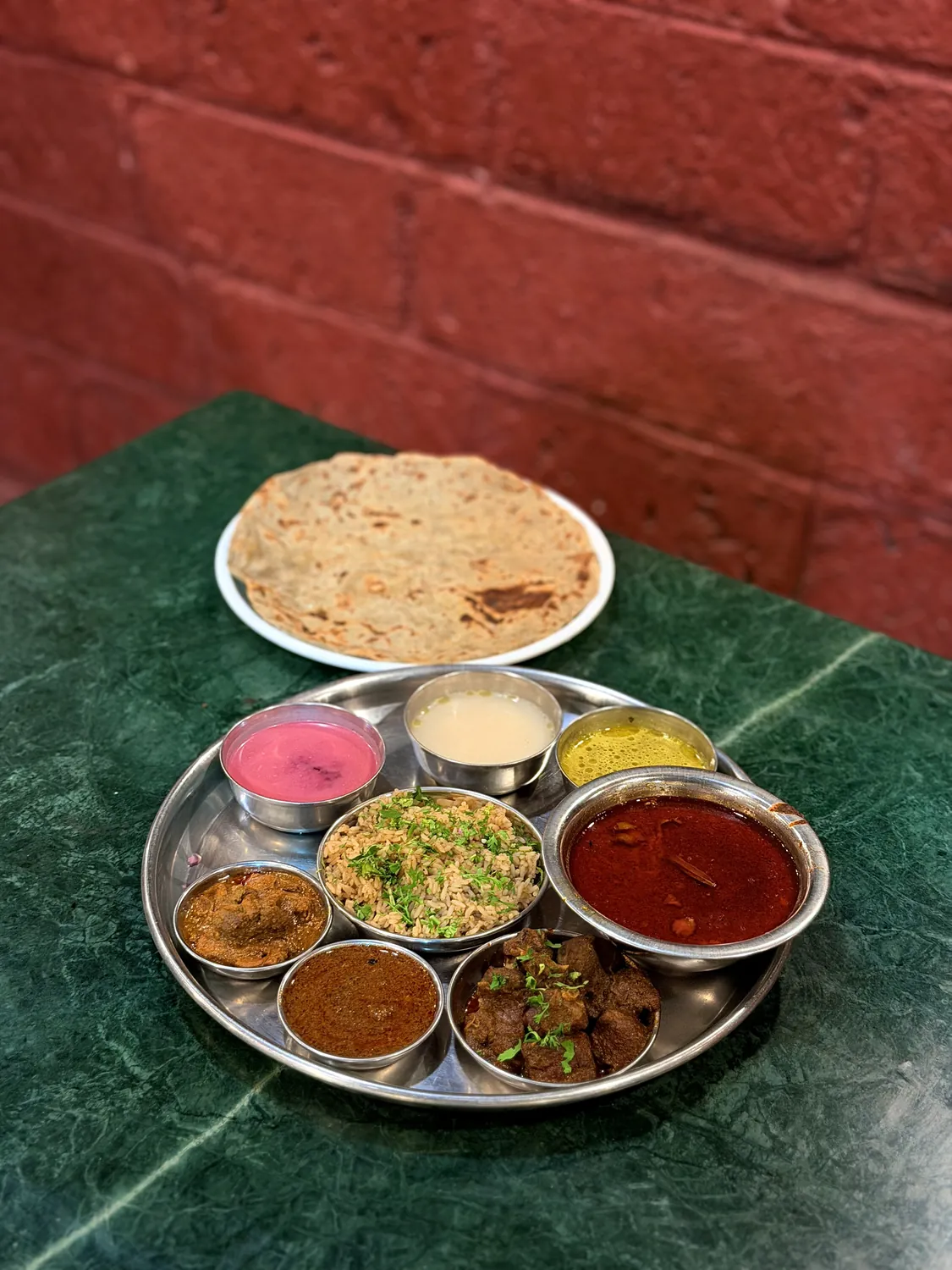A loaded non-vegetarian thali with rassa, sukka, rice and chapati